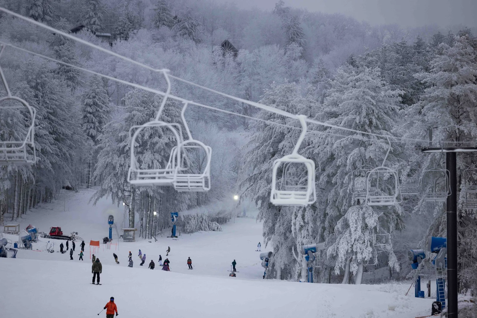 Chairlifts above skiers and snow-covered trees at Hatley Pointe